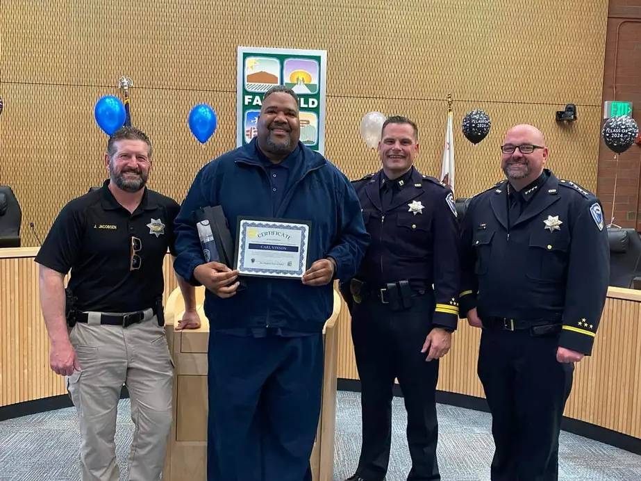 Carl Vinson holding a certificate with Fairfield police command staff in the council chamber